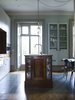 The kitchen island is a mahogany museum display case containing the clients’ inherited snuff-box collection. Now topped with salvaged iroko hardwood from a school science laboratory, it has also been adapted to hold a sink and washer. Photo of Strange Salvaged Materials and Objects in Modern Homes modern home