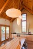 With exposed fir framing and clay plastered walls, the spacious dining room is the new social focus of the house. The custom dining table was created from salvaged bowling lanes. Connecting the home to the garden was a high priority, and a 14-foot-wide multi-fold door completely opens the dining room to the outdoors, while shading the interior space from the western sun. Photo of Strange Salvaged Materials and Objects in Modern Homes modern home