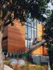 Modern home with Exterior, House Building Type, and Wood Siding Material. Baba and Bradley descend the staircase leading to the second-floor entrance, located above an in-law rental unit. The steel buoys are World War II era. Photo of Strange Salvaged Materials and Objects in Modern Homes