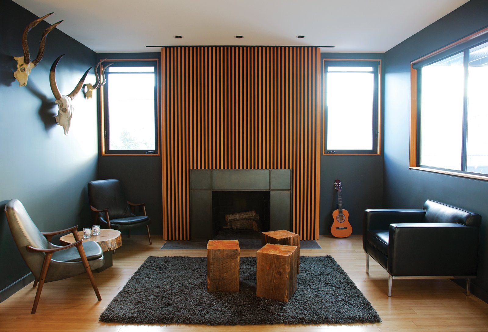 In Los Angeles, homeowner Bill Thompson warmed up his otherwise dark living room with a series of Douglas fir slats applied above the fireplace, as well as other wood accents throughout the room; the slats provide both texture and pattern to the fireplace, acting as a focal point and emphasizing the space's vertical height.