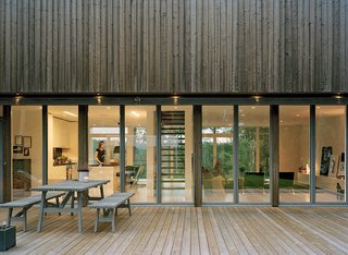 The Plus House—named for the perpendicular trajectories of light and air that pass through on the top and bottom floors—is one in a series of architect-designed homes commissioned by Arkitekthus, a development company founded five years ago with a pledge to improve the quality of prefab architecture. The spruce panels that coat the second-floor exterior will fade in tandem with the zinc-coated steel that rims the glazed windows and doors. "They will go gray like we do," says architect Claesson Koivisto Rune.