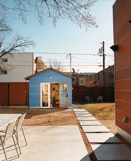 For artist Heather Kahn, a backyard painting studio attached to her home's original garage is the perfect place to work. The light blue paneling echoes the wood paneling on the main house, but the color distinguishes it and gives it a sense of personality.