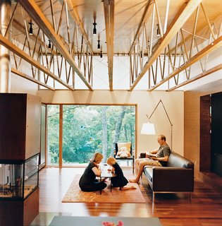 In the main living area, Eric sits on a Theatre sofa from Design Within Reach, while JJ and Ella lay at the Girard table from Knoll. Also seen here are a Brno Bar chair, also from Knoll, and the Tolomeo Mega floor lamp by Artemide.