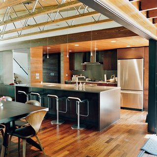 The couple opted for a smaller kitchen without fussy appliances and a larger dining area. They concentrated on achieving a high-quality space through carefully chosen furnishings, including the Cross Extension table in wenge, a Cherner side chair, and the LEM Piston stools, all from Design Within Reach.