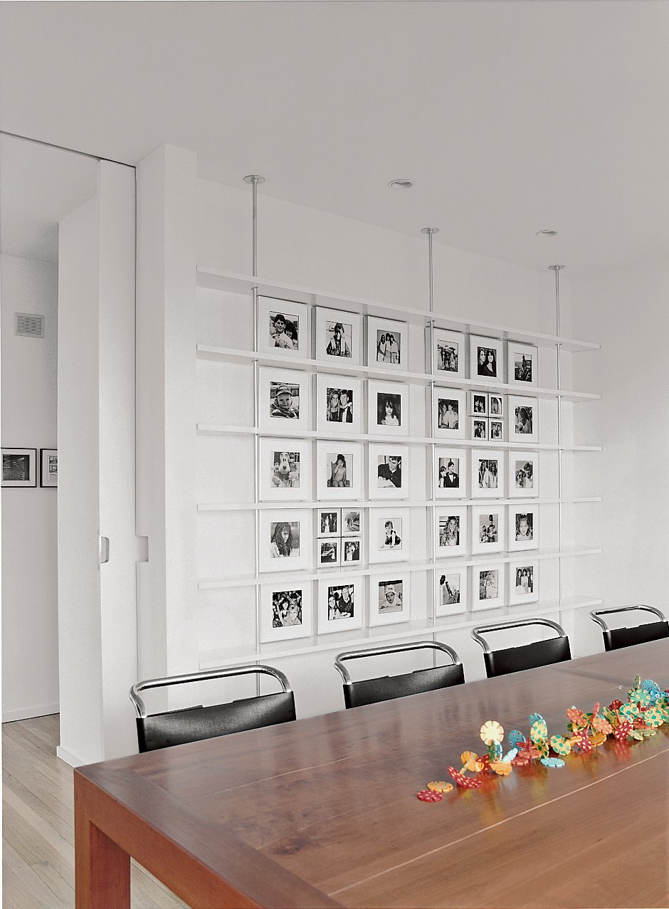 In the dining room, Mies van der Rohe chairs surround a custom-made cherry table. Black-and-white photographs of Sasseen's children and grandchildren are arranged systematically on the back wall.