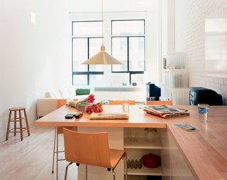 The combination dining table/countertop, says Woo, "is both a demarcation and connection between the kitchen and main living space." Originally, the architect considered a concrete surface, but balked at the delivery time and expense. "I kind of like it as it is built," he says. "All the horizontal surfaces are wood." The Conical pendant lamp is by Jorgen Gammelgaard and the Compasso d’Oro bar stools are by Enrico Franzolini.
