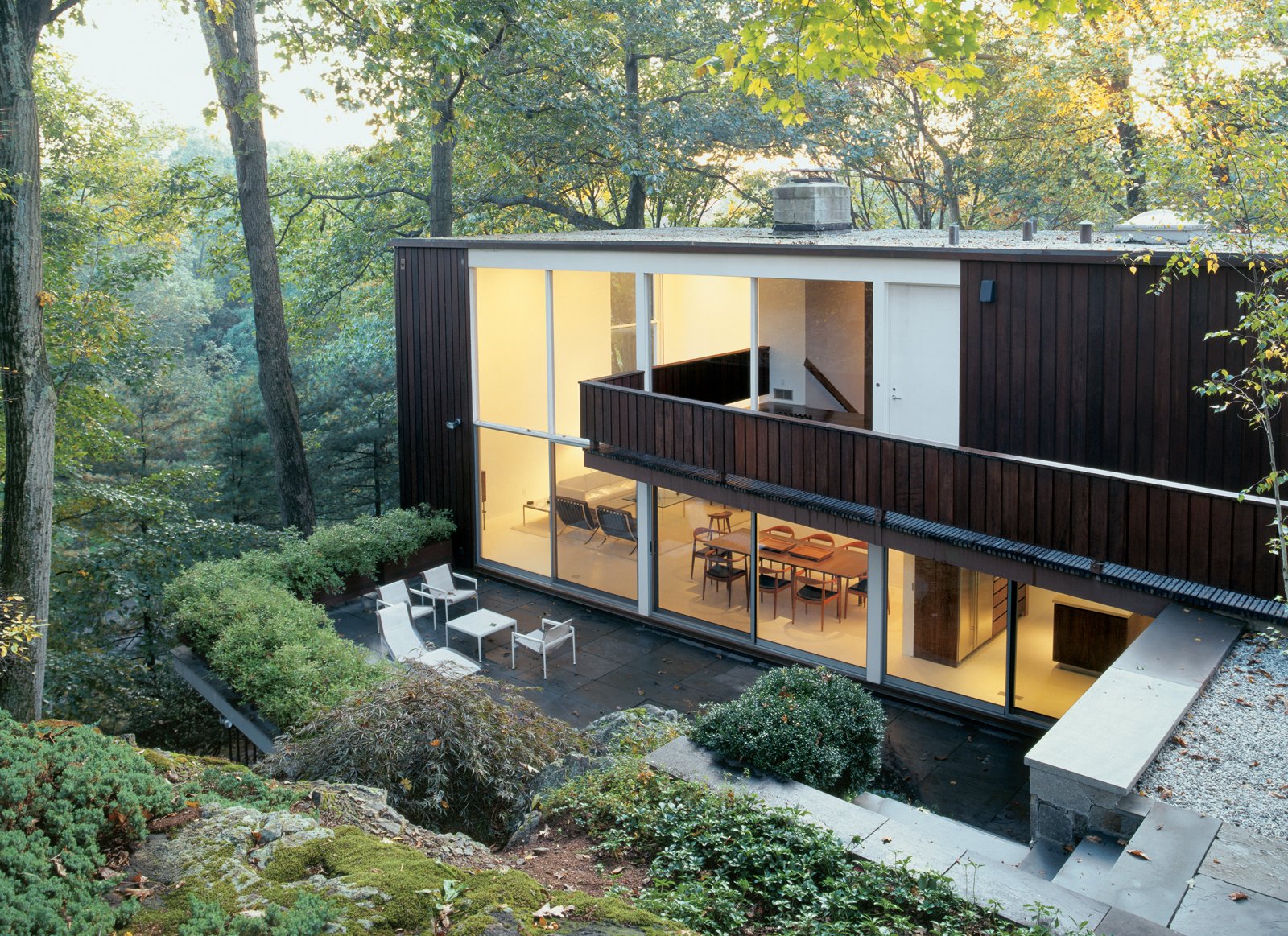 "We didn't realize the exterior was straight-grain redwood," says Craig Bassam of the house he shares with Scott Fellows. "It was covered in layers of gray paint." Bassam replaced the terrace's concrete pavers with bluestone and removed a concrete-block wall.