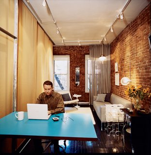 Checking email over coffee, Hughston places his laptop on the fold-down Formica table that Sanders designed. Jack Lenor Larsen's Cybelle fabric covers the wall on his right. Above the sofa hangs an Italian pendant lamp of mysterious origin; if you recognize it, please contact us.