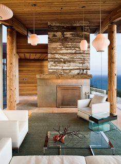 A reclaimed-wood fireplace is a defining feature in this living room.