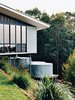 Modern home with Outdoor and Grass. The studio is clad in corrugated tin, echoing the adjacent water-storage tanks, which collect and filter rainwater off the roof. Photo of Steel Yourself