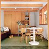 Modern home with Living Room, Sofa, Chair, Rug Floor, and Carpet Floor. Even in the Stonorovs’ tiny first-floor room, the curse of the kitchen as the inevitable gathering place lives on—–though the two-foot space between the sink and metal island is less than ideal for the family of three and their blue heeler, Oscar. Photo of Inside 5 Tiny Homes, All Under 600 Feet