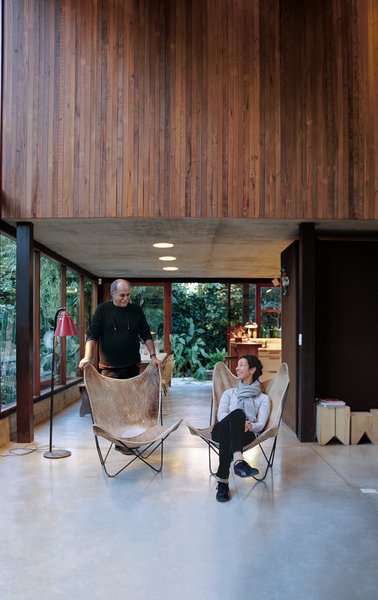 Sticotti and Hernaez relax in their living room, where custom-built windows and sliding doors enhance the indoor-outdoor effect.