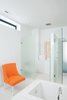 Modern home with Bath Room, Enclosed Shower, Porcelain Tile Floor, Drop In Sink, and Two Piece Toilet. The master bathroom, with its frosted glass walls and chair (rescued from the trash pile and rehabbed), is large and elegant enough to serve as a gathering place for parties. Photo of Designing for Privacy: 14 Discreet Uses For Frosted Glass