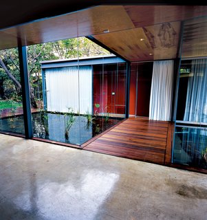 The Bercy House is a beautiful combination of functional architecture and modern aesthetics that is as much a sculptural showcase as a functional home. Two steel-framed rectangular volumes—one has a single story and the other has two—stand parallel to each other, though they have been staggered to take full advantage of the narrow lot and to provide ample outdoor living space. The buildings are connected by a glass-walled hallway that bridges a reflecting pool and water garden and there is an abundance of over-sized sliding windows, doors, and glass panels to blur the line between the built environment and the natural one.