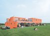 Modern home with Exterior, Apartment Building Type, and Flat RoofLine. Bob Krone and Paula van Dijk go for a walk while Lucas and Jillis Noordhoek lounge on the grass. Their parents, Jacquelien and Cees Noordhoek, chat farther to the right. Photo of How to Design with Orange