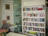 A colorful bookshelf sits just behind the table and actually mirrors the colorful stacks of tea in the kitchen space. It's a lending library that addresses many aspects of having and living with cancer, making it one of the valuable resources at Maggie's Center. Photo of Maggie's Center by Zaha Hadid modern home