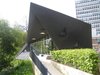 Here's another view of the terrace pulled back a bit. The sharp, triangular form of the building is echoed by the windows and lights. It's also rather low and small, emphasizing the human scale of the care given inside. Photo of Maggie's Center by Zaha Hadid modern home