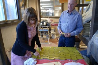 Catherine Bailey and Christopher Deam examine a tile board at Heath's factory.