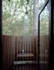 An aluminum-and-glass door, chosen for its ability to handle exposure to water, leads from the bathroom to the outdoor shower. Photo 6 of Texas Bunkhouse modern home