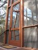 The nine-by-three-foot mahogany entrance door is meant to evoke the surrounding trees. The iron handrails lining the base of the porch are a subtle architectural detail, as well as a support system to prevent the cabin from ever twisting or shifting “like so many old Texas outbuildings,” says Panton. Photo 7 of Texas Bunkhouse modern home