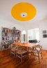 An industrial shelving unit holding Jones' library contrasts with the warm wood flooring and furniture in his dining room. Photo of Canada's Design Domestic modern home