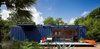 Modern home with Exterior and Shipping Container Building Type. While shopping for containers, Hill was instantly drawn to this one’s existing blue color and chose to buy it and leave it as is. Poteet added floor-to-ceiling sliding doors to allow light in, as well as a cantilevered overhang to shade a window on the left side, which houses a small garden storage area. Photo of How to Design with Orange