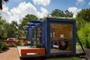 Modern home with Exterior, Small Home Building Type, Shipping Container Building Type, Metal Roof Material, Metal Siding Material, Glass Siding Material, and Flat RoofLine. The architect and his team devised an armature on the back of the container that will eventually be covered with vines, concealing the AC and heating unit, the reservoir for graywater and the composting toilet outlet. Photo of Amazing Examples of Shipping Container Architecture