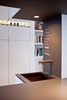 Chris painted the partial wall (above the Vigo Industries sink and Cifial faucet) in Rust-Oleum chalkboard paint. "It's kind of hokey," he says, "but I actually do use it." Most recently on the board: "bread", "OJ", "milk" (crossed off), and "mayonnaise" (crossed off). "It's convenient when we're cooking and run out of stuff. We write it down and then transfer it to the grocery list later," Chris says. Up next for Chris are a cottage project in Ontario, Canada, and a loft renovation in Boston. But with two of their own kitchen renovations completed within the past two years, the Greenawalts are now ready to rest and stay put in their own home and savor the results. Photo by Kate McElwee. Photo of D House Kitchen Renovation modern home