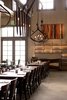 For overhead decorations, the team took to the road in search of vintage farm tools--and often didn't have to travel very far. On the Long Meadow Ranch land, they found the large wooden hay hook that hangs in the middle of the dining room. Johanson assures "it's pretty warm and rugged," though it quickly conjures up the scene from Twister when Helen Hunt attempts to find safe haven in a barn only to discover its filled with razor-sharp farming tools. "It looks more pointy than it is in the images," Johanson says. Photo of Farmstead Restaurant modern home