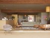 Modern home with Living Room, Chair, Sofa, Pendant Lighting, and Brick Floor. Pearson and Trent furnished the house with lamps and chairs they culled from vintage stores in the area. They found the overstuffed leather lounger at Surfing Cowboys in Venice. The couple and the architects collaborated on the couch design and had it fabricated. Works by local artists fill their home, such as the white vessels by California-based, Japanese-born ceramicist Shio Kusaka. Photo 6 of Pearson Trent Residence
