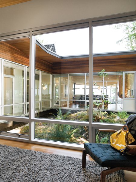 The plan of this house in British Columbia by Vancouver architects Heather Howat and David Battersby of BattersbyHowat Architects revolves around a rocky outcropping lush with life that acts as the home’s central atrium. The granite was left intact in order to serve as the nucleus of the courtyard, and the walls of windows draw a wealth of natural daylight into the back of the building.