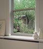 The master bedroom looks onto the roof garden and the backyard beyond. Under the window, built-in cabinetry also hides the radiator. Photo of Soho Row House Renovation modern home