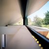 Modern home with Windows. The deep-V, butterfly roof characterizes the hut on the outside and defines the interior as well. "It was a result of several experiments to maximize the reflective light effects, channel the rainwater into the pond, and capture a view of the sky," Poss says. Photo by Phillip Kalantzis-Cope. Photo of Butterfly Roof Meditation Hut