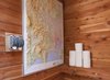 A peek inside the bathroom, where a raised topographic map doubles as reading material and travel inspiration. Photo of How to Design With Maps modern home