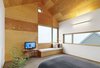 Inside the master bedroom, the juxtaposition of old and new is pronounced. Wooden furniture sits next to a streamlined built-in bench. The wood-framed windows open up to views of the gabled roof. Photo 6 of The Farm modern home
