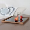 Architect Finn Juhl designed predominantly in the 1940s and 50s and created the TurningTray in 1956 to match the furniture in his house. The curvature of the teak eliminates the need for handles and the two sides—one laminated in black and the other in either red, white, light green, or pale blue—let it transition from day to evening use. Photo of Architectmade modern home