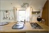 The countertop is from Ikea, the camping sink is by Thetford, and the stove is by Ramblewood. Photo of Big Sur Airstream Renovation modern home