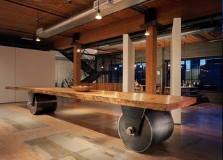 This artist’s studio was created out of two bays on the second floor of a former warehouse. Sliding and pivoting 9’x9’ wall panels run adjacent to the large central wood beam and allow the 3,750 square-foot space to be reconfigured as needed. A "working wall" runs the entire length of the south wall, pulling away from the exterior wall in one area to provide space for a utility room and bathroom. A new steel stair was inserted to connect the ground floor to the studio and up to a small roof deck. A skylight tops the stairwell to bring daylight into the studio and down to the entrance. The building’s history and its uses remain evident in the patina of the floors which were simply cleaned rather than resurfaced. Photo by Benjamin Benschneider.