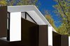 The wood-and-metal exterior is all about the interplay of angles and planes. White Kynar-coated cladding tops rough-sawn pine planks stained a rich brown shade. Photo of Superior Logic modern home