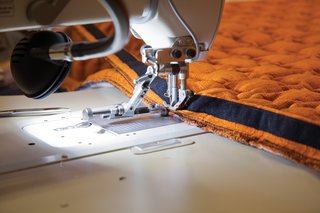 Sewers stitch zippers on to the cover’s edges to enable it to attach securely to the wooden sofa frame.