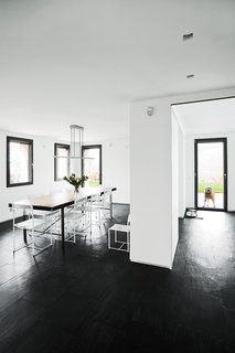 In the dining area a vintage table from a shop in Barcelona is surrounded by Giandomenico Belotti Spaghetti chairs. The space, which also includes the kitchen, occupies a 1970s addition.