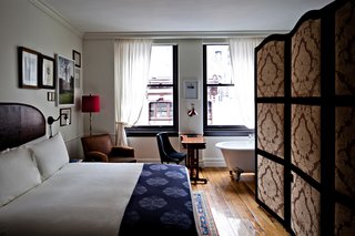 Here's a larger view of a guest room, showing how the typical room is structured like a self-contained studio apartment. Clawfoot tub included. The bathroom is hidden behind the upholstered screens at right, which could easily be replicated with a more modern fabric for a less traditional look.