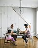 Modern home with Staircase and Wood Railing. At right, the family dines at a mid-century walnut table found on eBay,
seated at a mix of new and antique
Wishbone chairs by Hans Wegner. Photo of 17 Modern Homes With Hans Wegner Furniture