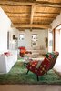 Modern home with Living Room, Chair, and Sofa. In Marquina and Font’s living room, a pair of kilim-covered chairs by Philippe Xerri, a chest of drawers by Piet Hein Eek, and a handmade Tunisian rug provide bursts of color amidst the overall scheme of white, ecru, and cream. Photo of Homes Filled with Colorful Furniture