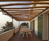 On the patio, robinia wood beams shade a Kettal Vieques dining table and set of Moroso Supernatural chairs. Photo of A Renovated Modernist Oasis in the French Riviera That Has Hosted Picasso and Royalty modern home