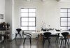 Metal-framed windows stand out against the white walls in this loft. Black Cherner chairs and a white table continue the motif. Photo of Monochromatic Color Palettes Are the Ultimate Modern Design Tool modern home