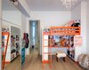 Modern home with Kids Room, Bedroom Room Type, Bed, and Bunks. The kids’ bedroom features playfully colored bunk beds from Ikea. The mirrored closet doors reflect light and make the room appear larger. The vertical light slot can also be viewed through the bedroom corridor. Photo of A Bright Brooklyn Loft with an Envy-Inducing Walk-In Closet
