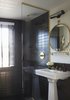 The bathrooms are clad in black Daltile and features brass hardware from Watermark in the European-style shower and on the sink. The mirror is custom. ASH worked with American Medicinal Arts on the custom-scented toiletries. "Because we are designers as well as developers, we pay very close attention to physical detail," Heckman says. "For us, part of the fun of doing a hotel was being able to focus on all of the touch points in a way you are not often able to on residential projects. It is tough to describe, but one of the main 'amenities' of The Dean is staying in a property where every detail, no matter how minute, has been thought about." Photo 14 of The Dean Hotel in Providence modern home