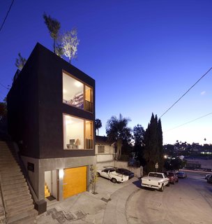 Storey calls this house the “Eel’s Nest,” after the narrow urban properties that go by that name in Japan. Its façade was originally going to be wood, but because of local building codes and the fact the building is built along the edge of the property line, the exterior had to be fireproof. Storey covered it with stucco instead. “I wanted it to look as rough as possible,” says the architect. “Since it’s such a small house, it needed to be tough-looking.”

The workshop at ground level measures less than 200 square feet, but is set up to accommodate any kind of woodworking or welding; when not in use, the architect parks his car inside.