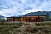 Floor-to-ceiling windows enclose the living and dining space, flooding the room with sunlight. This warmth is retained by a radiant heating system in the concrete floor, which significantly reduces heating requirements during the night. The exterior features a concrete skirt that’s impermeable to snow pack moisture, and weathering steel panels that are resistant to brush fires. Photo of Modern Mountain Retreat in Washington modern home